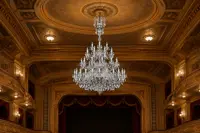 Duży wielopoziomowy żyrandol kryształowy w historycznej sali teatralnej