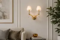 Mosiężny kinkiet nad konsolką w przytulnym salonie