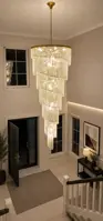 Spiralna kryształowa lampa w dwukondygnacyjnym holu wejściowym ze schodami